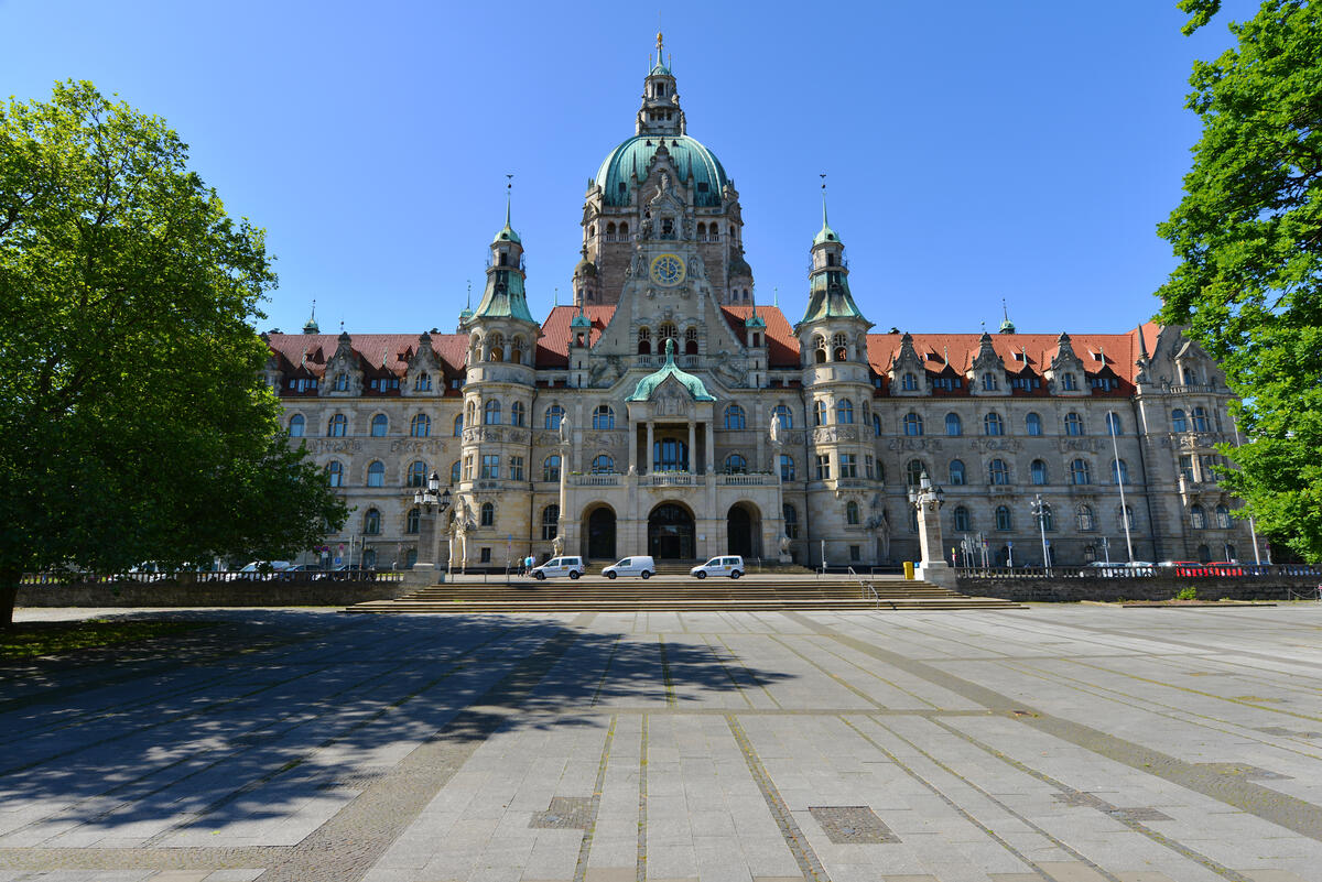 Das Neue Rathaus am Trammplatz, eingerahmt von grünen Bäumen
