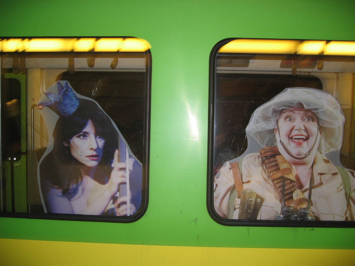 Grüner Stadtbahnwagen mit Fensterwerbung