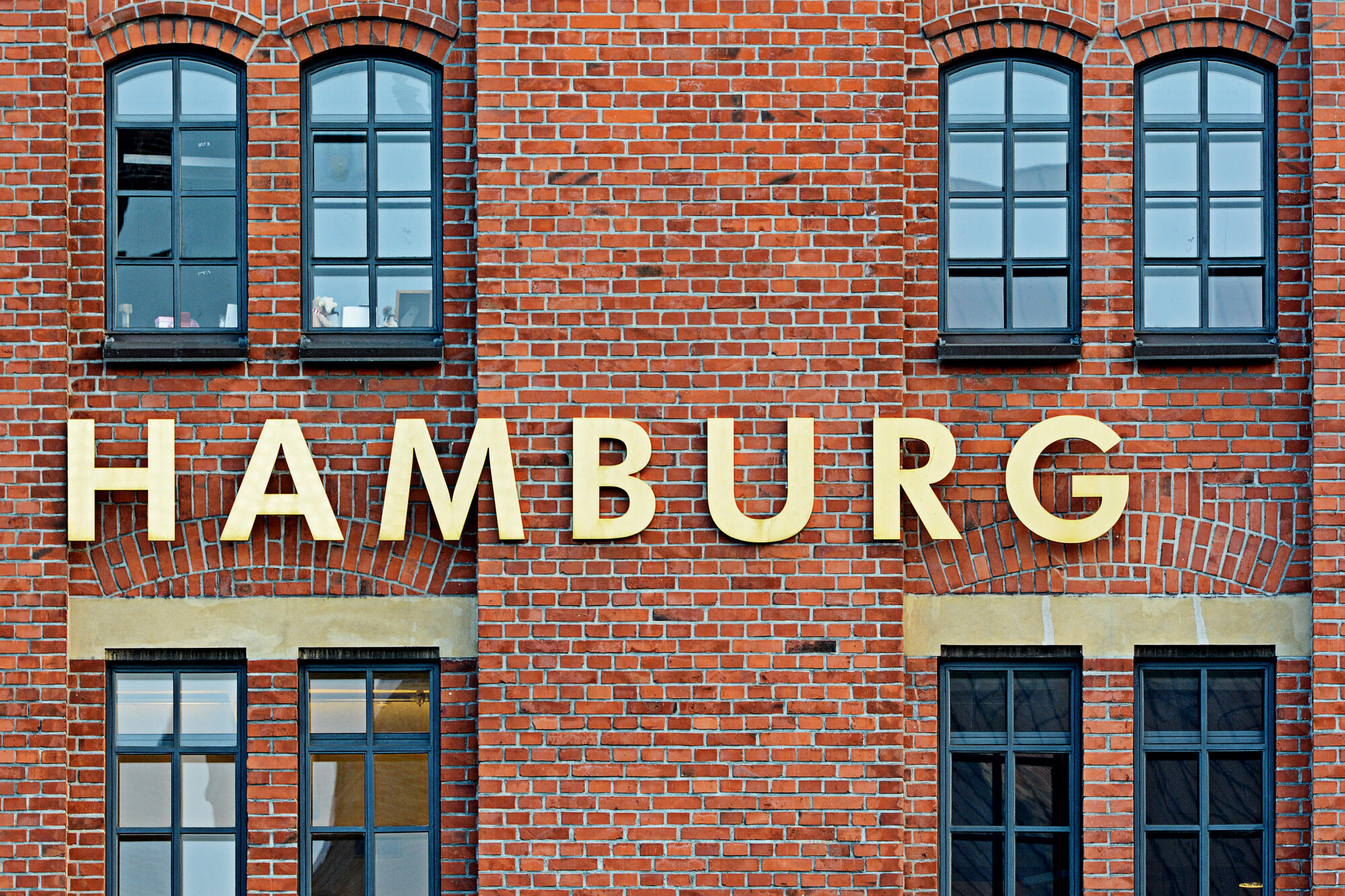 Hamburg-Schriftzug auf einer Backsteinfassade.