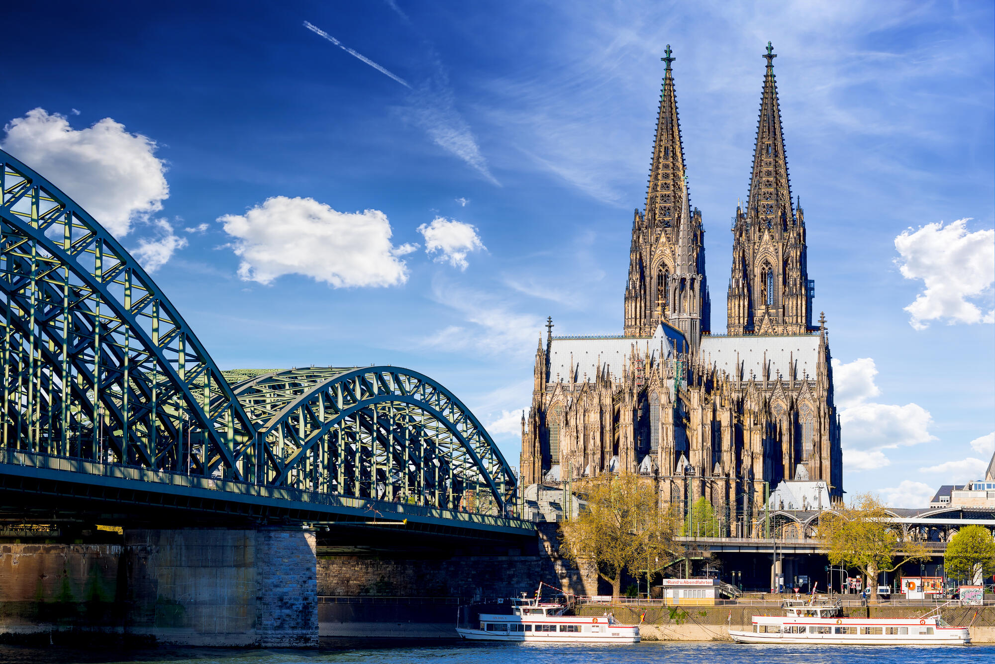 Kölner Dom und Hohenzollernbrücke bei Tageslicht.