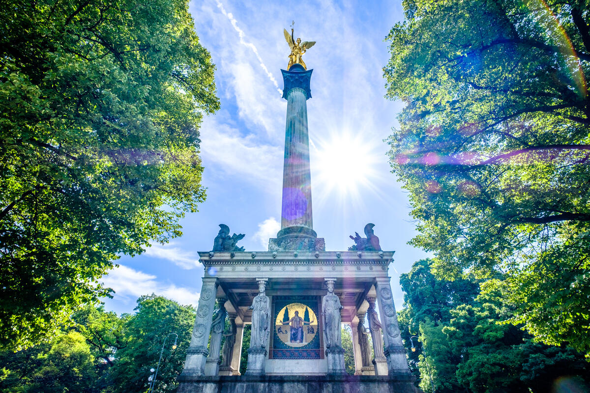 Friedensengel zwischen grünen Baumkronen.