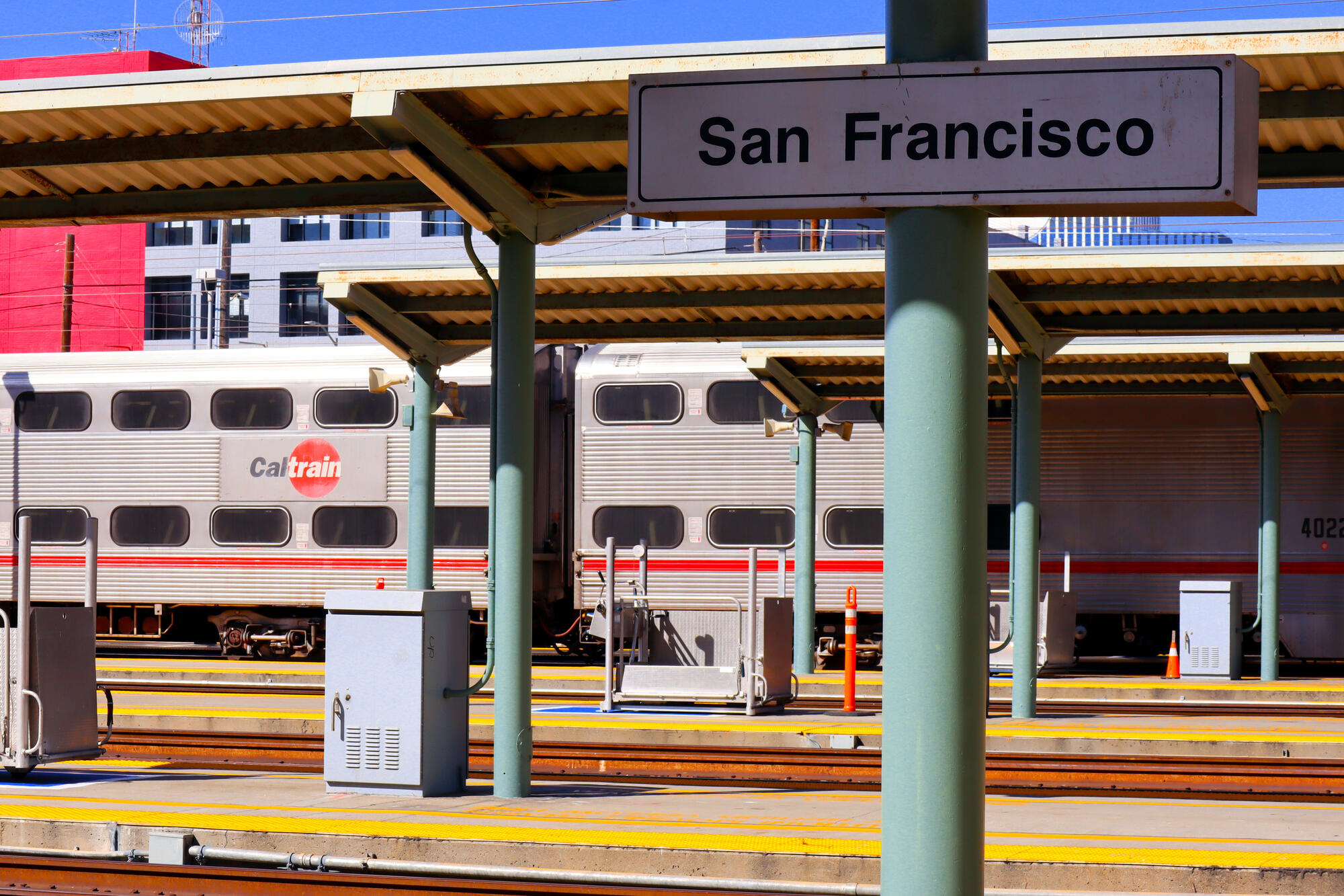 Die Aufnahme von 2023 zeigt einen doppelstöckigen Caltrain-Wagen unter den Bahnsteigdächern und das Stationsschild San Francisco.
