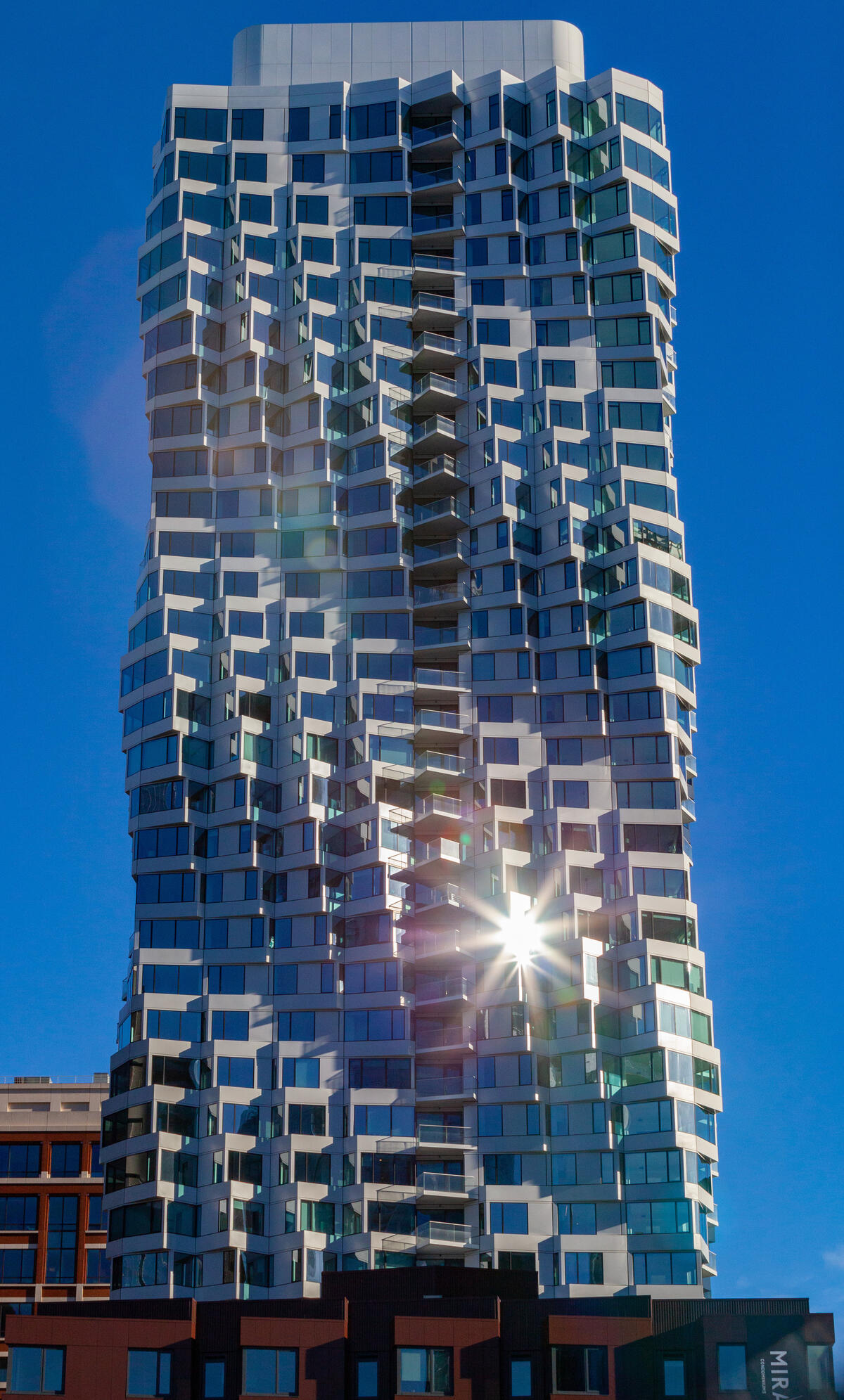 Helle, versetzte Erker gliedern die gläserne Fassade des MIRA Tower und erzeugen eine gedrehte Silhouette.