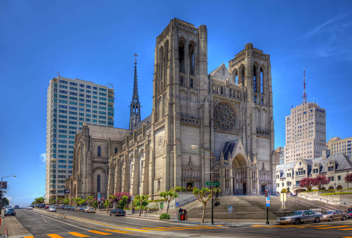 Die Fassade der Grace Cathedral mit zwei Glockentürmen, Rosette und breiter Eingangstreppe unter blauem Himmel.