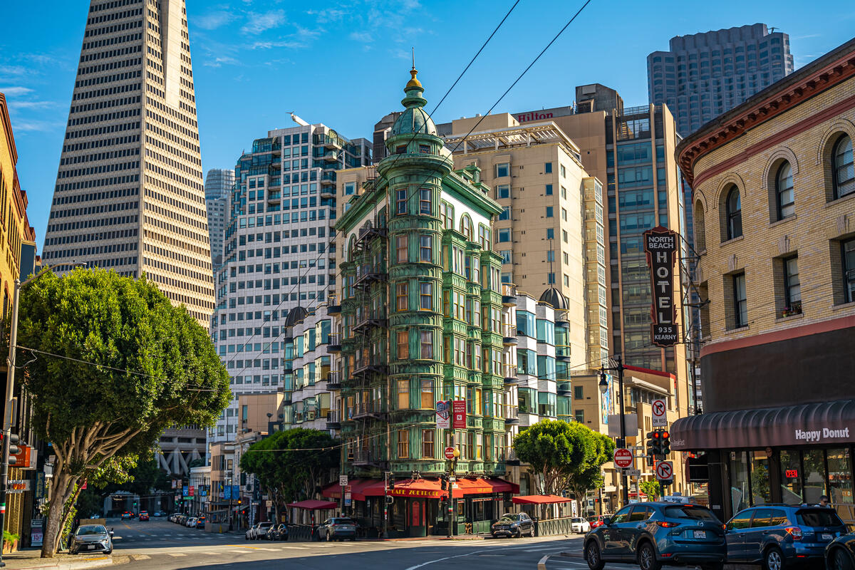 Die grüne Erkerfassade und das runde Ecktürmchen des Sentinel Building stehen im Straßenbild vor der Transamerica Pyramid.